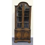 A 20th Century Queen Anne style walnut corner cabinet, fitted with a pair of glazed doors above a