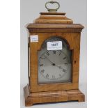 An early 20th Century walnut cased mantel timepiece, the break arch silvered dial with Roman