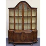 An early 20th Century walnut Queen Anne style display cabinet, with a domed scrolling pediment above