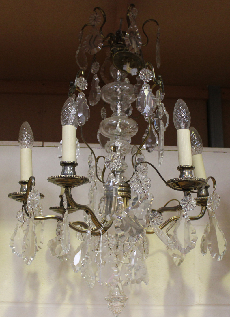 An early 20th Century gilt metal and cut glass six branch ceiling light, hung with overall lozenge