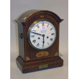 An Edwardian mahogany mantel clock with eight day movement striking on a gong, the enamel dial