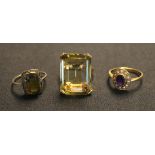A gold ring, claw set with a rectangular step cut citrine, detailed '18K', a gold, amethyst and seed