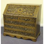 An early 20th Century Continental oak bureau, with a heavily carved floral decorated fall flap above