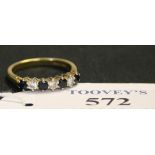 An 18ct gold, sapphire and diamond seven stone half hoop ring, claw set with four circular cut