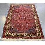 A Hamadan rug, North-west Persia, mid-20th Century, the red field with overall herati, within an