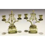 A pair of late 19th/early 20th Century French gilt metal and white marble twin branch candelabra,