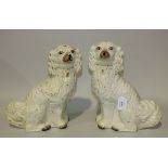 A pair of Staffordshire pottery models of seated spaniels, late 19th Century, with gilt and