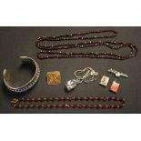 A single row necklace of garnet beads, a single row necklace of faceted red paste beads, a Middle