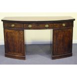 A George IV mahogany bowfront twin pedestal sideboard with a flame figured top and reed moulded