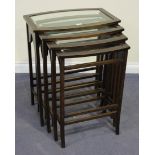 A George V oak nest of quartetto occasional tables, each bowfront top inset with a bevelled glass