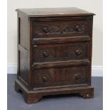 A 20th Century Jacobean style oak chest of three long drawers, with carved decoration, on shaped