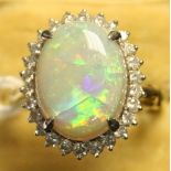 A gold, opal and diamond oval cluster ring, claw set with the oval opal within a surround of