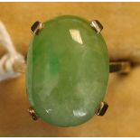 A gold ring, claw set with an oval cabochon jade.