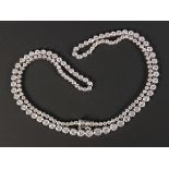 A platinum and diamond necklace, collet set with a row of circular cut diamonds graduating in size