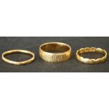 Two 22ct gold wedding rings, and an 18ct gold wedding ring with a bark textured finish.