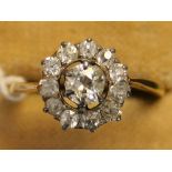 A gold and diamond cluster ring, claw set with the principal cushion shaped diamond within an