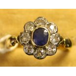 A gold, sapphire and diamond set cluster ring, mounted with the oval cut sapphire within a