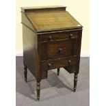 A late George III mahogany campaign washstand, the hinged lids enclosing a cistern and a brass tap