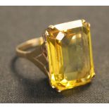 A gold and rectangular cut yellow gem set solitaire ring, detailed '9ct'.