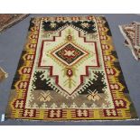 A Turkish kelhim rug, early 20th Century, the ivory field with a hooked medallion, within a claret