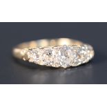 A gold and diamond set five stone ring, mounted with a row of cushion shaped diamonds graduating