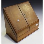 A late Victorian oak stationery box, the sloping double-hinged lid enclosing a letter rack and