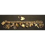 A 9ct gold curblink charm bracelet, fitted with a variety of mostly 9ct gold charms, with a 9ct gold