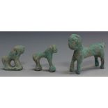 A group of three Islamic green patinated cast bronze figures of animals, including a seated lion,