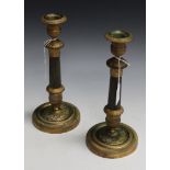 A pair of early 19th Century gilt metal candlesticks with overall foliate chased decoration, the