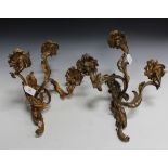 A pair of 19th Century Rococo Revival cast ormolu three branch wall lights of scrolling foliate