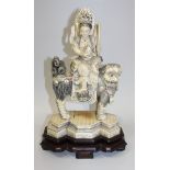 A Chinese carved ivory figure group of Guanyin and a Buddhistic lion, late Qing dynasty, the goddess