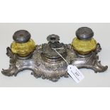 A Continental plated inkstand of rococo scroll form with a central taperstick flanked by a pair of