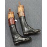 A pair of black leather riding boots, fitted with wooden lasts.