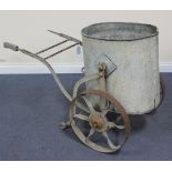 An early 20th Century galvanized metal oval water carrier, raised on a pair of spoked wheels, length