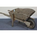 An early 20th Century wooden wheelbarrow with later wheel, length approx 133cm.