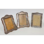 A pair of George V silver mounted photograph frames of shaped rectangular form, decorated with