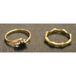 An 18ct gold wedding ring in a shaped design, and a 9ct gold, sapphire and diamond three stone ring,