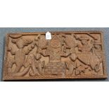 A carved hardwood rectangular panel, probably South American, decorated in relief with a native