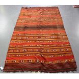 A Kurdish kelhim rug, early 20th Century, the terracotta field with banded stripes, approx 245cm x