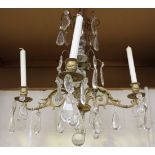 An early/mid-20th Century gilt cast metal and clear glass four branch ceiling light, hung with