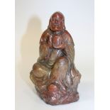 A Chinese carved soapstone figure of a sage, 19th Century, finely modelled in a seated pose, holding