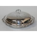 An Edwardian silver muffin dish and cover with foliate scroll handle above a beaded and scroll