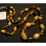 A single row necklace of graduated oval opaque and translucent vari-coloured treated amber beads, on