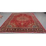 A North-west Persian carpet, late 20th Century, the claret field with a flowerhead medallion,