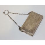 An Edwardian silver purse of rectangular form, hinged to reveal a fitted interior, the