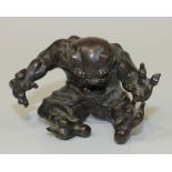 A Japanese brown patinated bronze figure of a seated oni, Meiji period, modelled with arms and