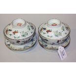 A pair of Chinese famille rose porcelain rice bowls, covers and stands, mark of Qianlong but