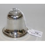 A George V silver novelty inkwell in the form of a bell with hinged lid and angular finial,