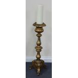 A mid-19th Century gilded metal pricket candlestick with reeded knop stem, the triform base