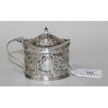 A late Victorian silver oval mustard with domed hinge lid and urn shaped finial, with overall floral